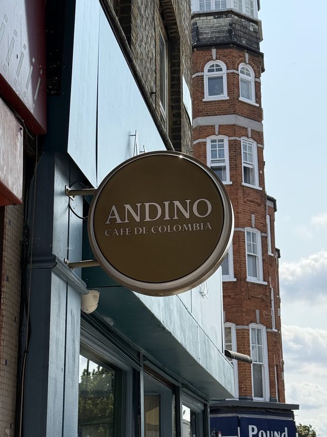 The round projecting cafe sign against the brick corner building